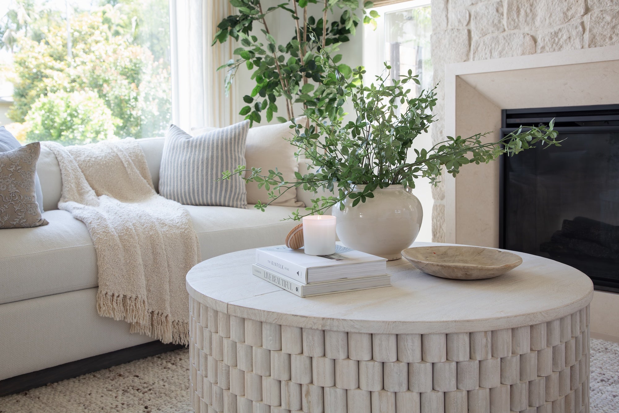 Living room with a white sofa, coffee table, and decorative elements.