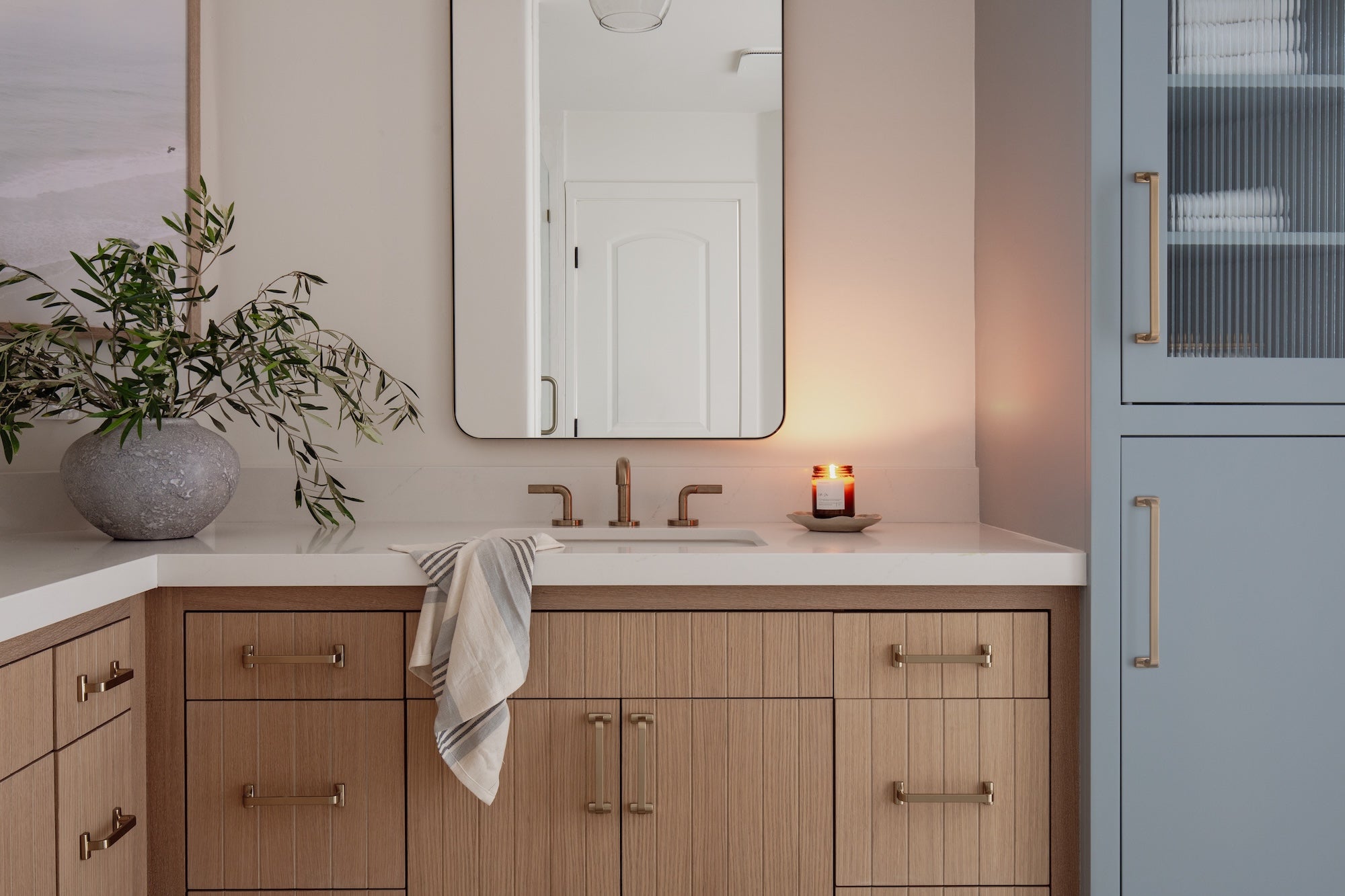 Bathroom with wooden vanity, mirror, and decorative elements.