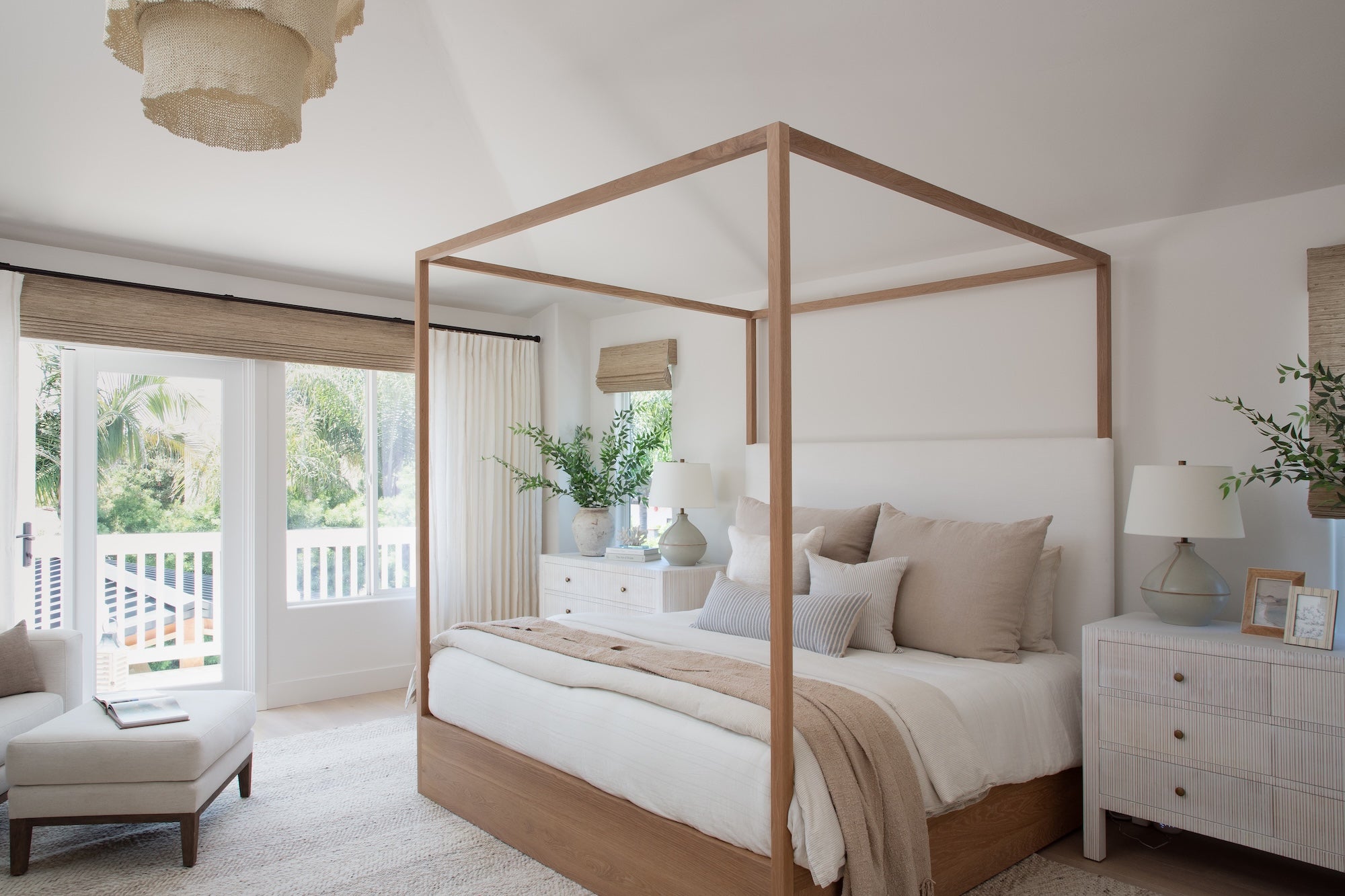 Neatly arranged bedroom with a canopy bed, white bedding, and neutral decor.