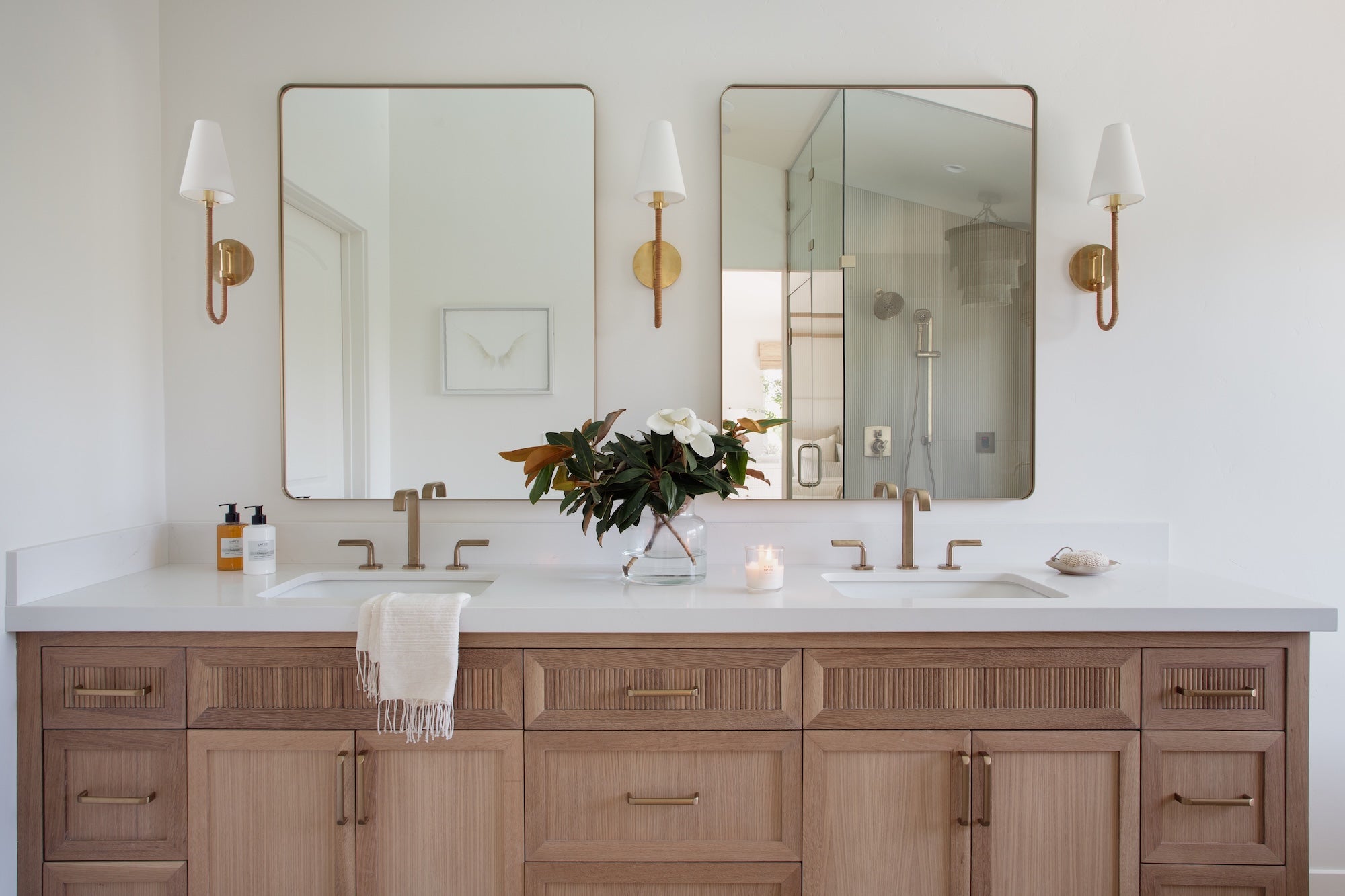 Bathroom with double vanity, mirrors, and decorative elements.