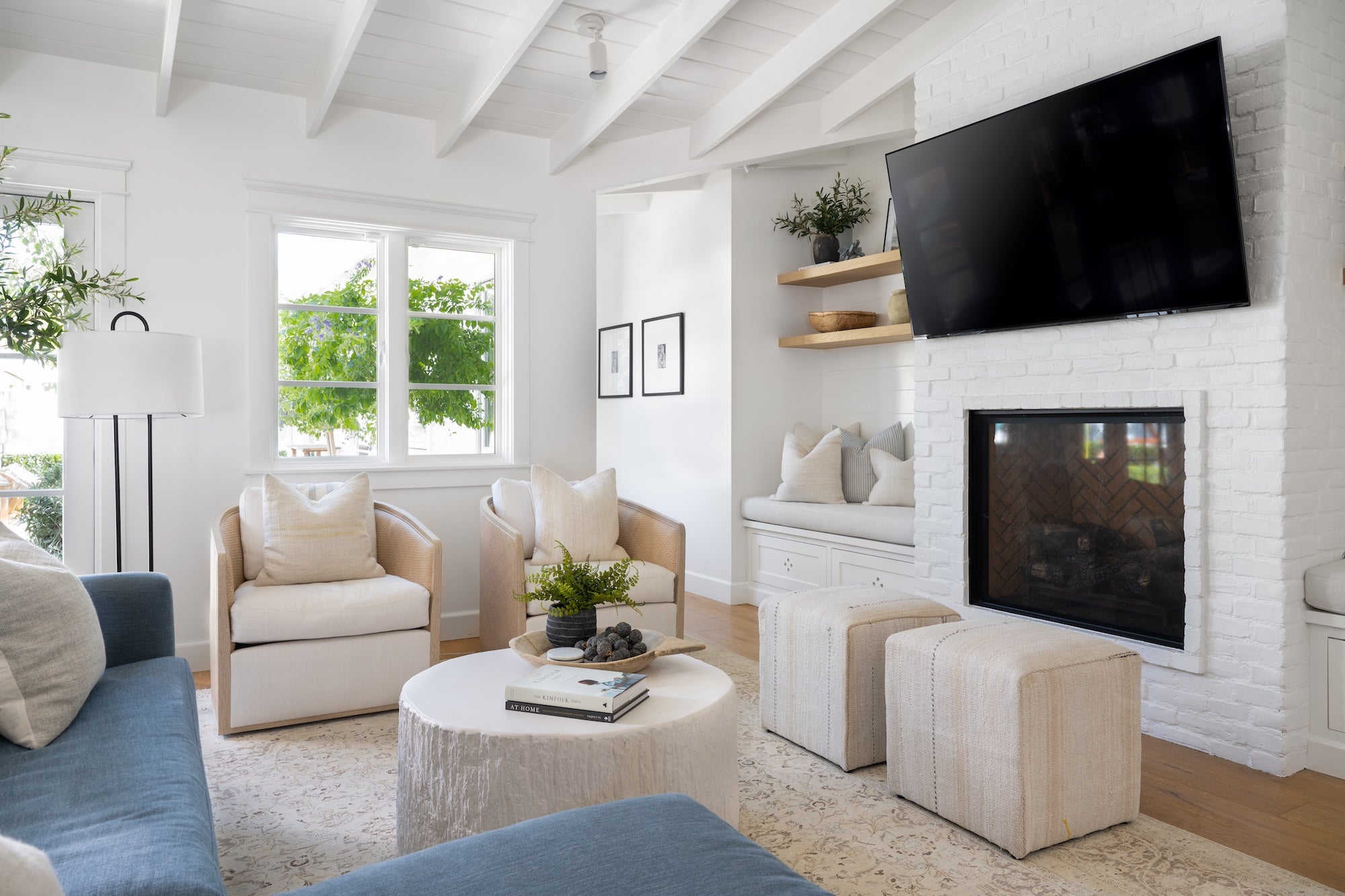 Modern living room with white walls, a fireplace, and a television.